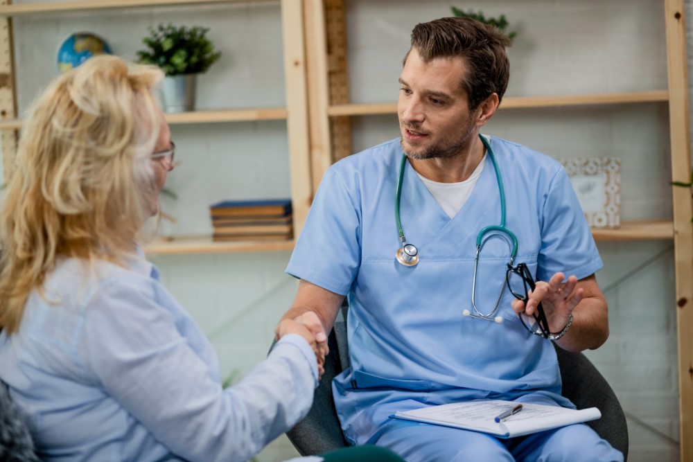 A doctor speaking with a patient in a consultation room
